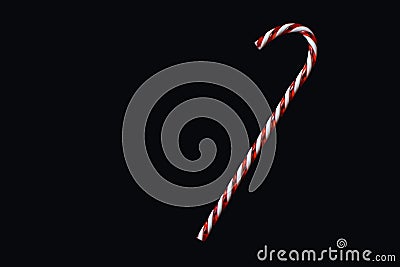 Red and white traditional Christmas candy cane on black background greeting card motive Stock Photo