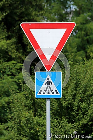 Red and white triangle give way or yield road sign above pedestrians crossing blue and white rectangle small road sign Stock Photo