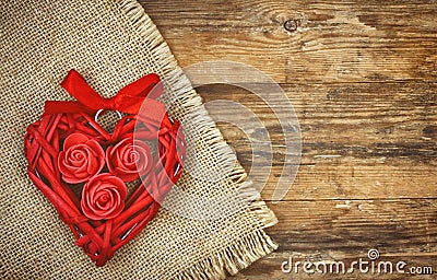 Red wicker heart with roses and ribbon, canvas napkin Stock Photo