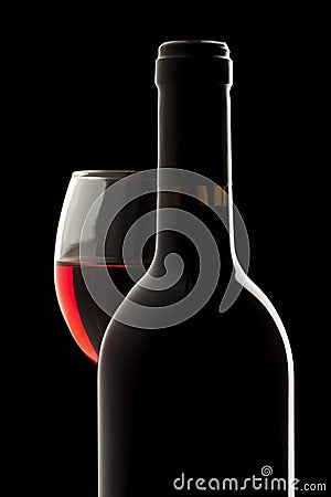 Red wine bottle and wine glass in a black backgrou Stock Photo