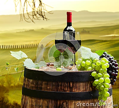 Red wine bottle and wine glass on wodden barrel. Beautiful Tusca Stock Photo