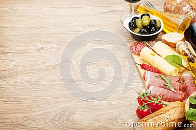 Red wine with cheese, prosciutto, bread, vegetables and spices Stock Photo