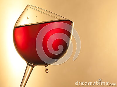 Red wine in the glass tilted with golden drop and space for text Stock Photo