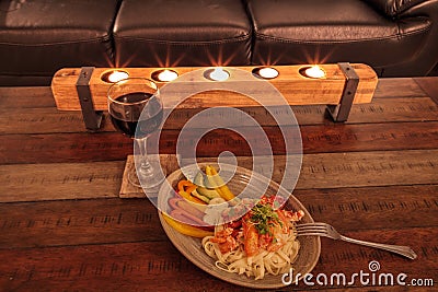Red wine with Maine lobster over a bed of linguini with micro greens Stock Photo