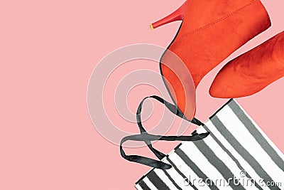 Red women boots and black shopping bag on pink background. Flat lay, top view trendy fashion feminine background. Beauty blog Stock Photo