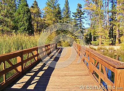 RED WOODEN BRIDGE TO THE FOREST Stock Photo