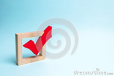 red wooden checkmark for voting on elections on a blue background. Presidency or parliamentary elections, a referendum. Survey Stock Photo