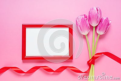 Red wooden frame, tulips and red satin ribbon Stock Photo