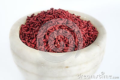 Red yeast fermented rice or kojic riceRed yeast fermented rice on mortar grinding bowl Stock Photo