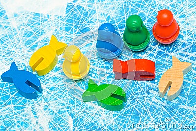 red, yellow, blue, green fish and penguin wood chips figure in children play - Board game and kids leisure concept Stock Photo