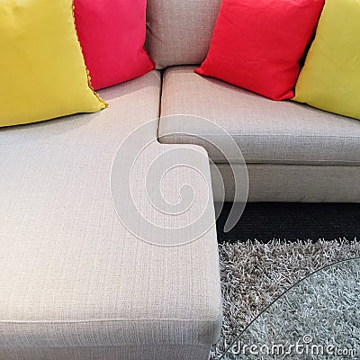 Red and yellow cushions on gray corner sofa Stock Photo