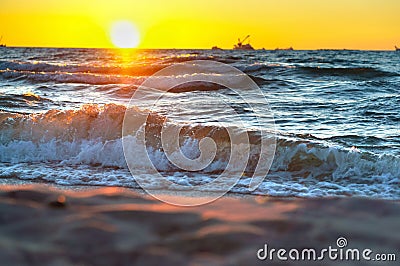 Red yellow sunset on the sea shore, in the surf of the waves of the Baltic sea, a magnificent sunrise Stock Photo