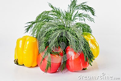 Red and yellow sweet large peppers, above them a bunch of dill Stock Photo