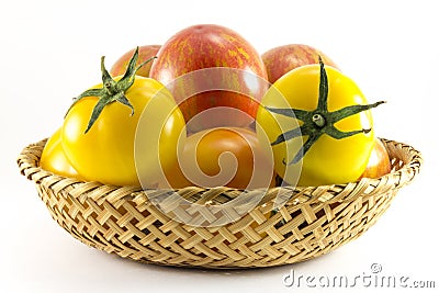 Red and yellow tomatoes in wicker oval shape Stock Photo