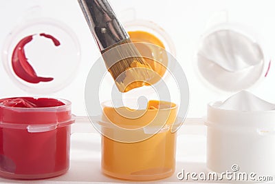 Red Yellow White Acrylic Paints and Paintbrush Stock Photo