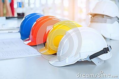 Red Yellow White and blue Safety hard hat on the blueprint with Stock Photo