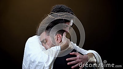 Redeemer hugging unhappy man, faith in God, spiritual protection, eternity Stock Photo