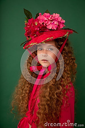 Redhair beautiful girl with curly afro curls in bright pink dress on green background. Curly hair care, freckle cream, teen book Stock Photo