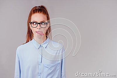 Redhair ginger woman demonstrating tongue and making stupid face with crossed eyes Stock Photo