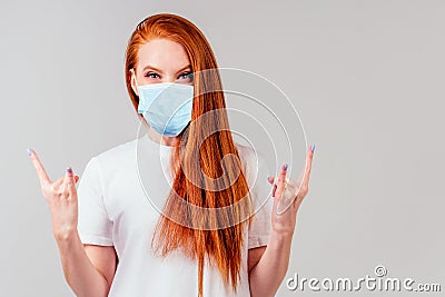 Redhaired ginger woman in white cotton t-shirt showing rocks fingers Stock Photo