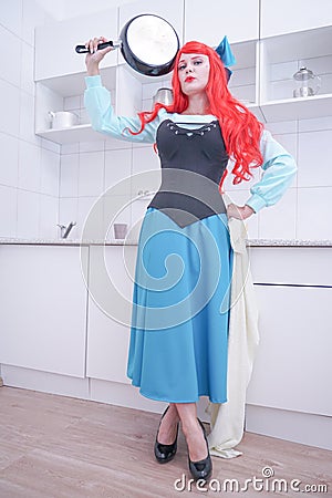 Redhaired plus size angry sad woman holding frying pan Stock Photo