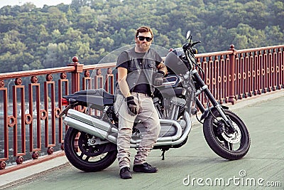 Redhead biker with beard in leather jacket and his bike. Stock Photo