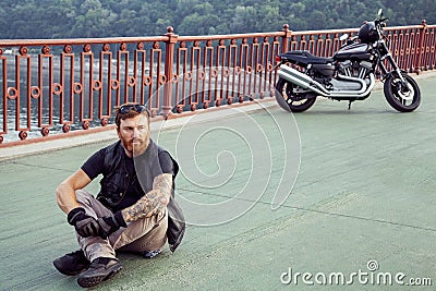 Redhead biker with beard in leather jacket and his bike. Stock Photo