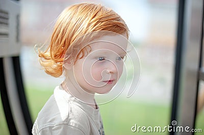 Redhead child thinks and looks into the void Stock Photo