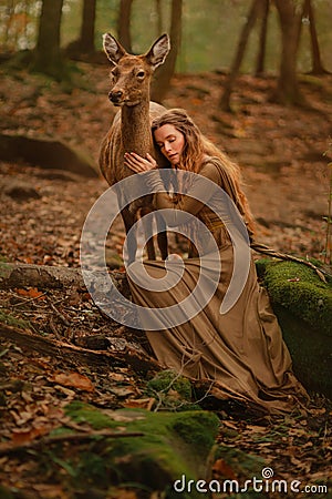 Redhead girl with deer in a long dress Stock Photo