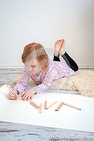 Girl draws with pencils lying on the floor Stock Photo