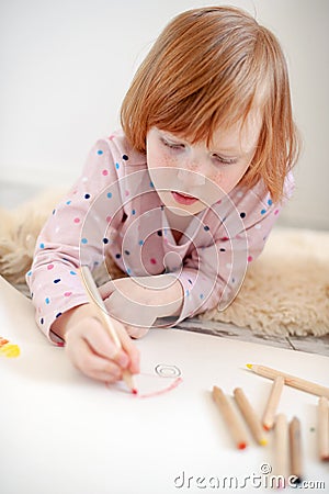 Girl draws with pencils lying on the floor Stock Photo