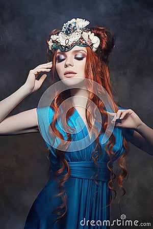 Redhead girl fabulous look, blue long dress, bright makeup and big eyelashes. Mysterious fairy woman with red hair. Big eyes Stock Photo