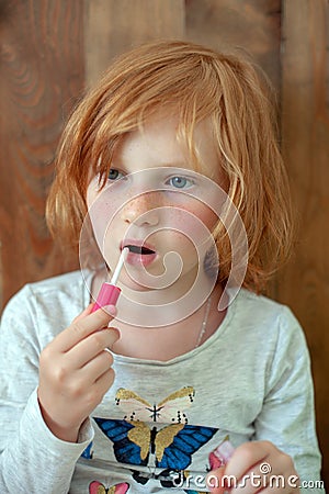 The girl paints lips with brilliance Stock Photo