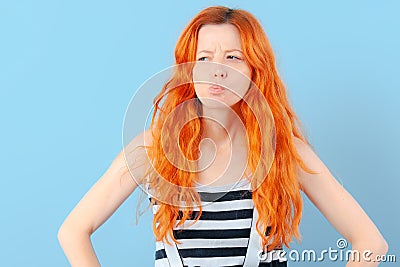 Redhead girl squints and frowns. Doubt, choice and suspicion Stock Photo