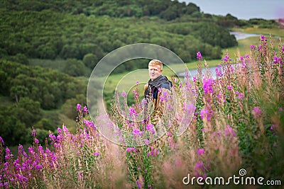 Man stands in thickets of fireweed at Kamchatka. Stock Photo