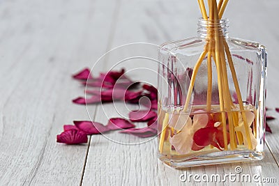 Reed diffuser with fragrance in a glass jar with rose petals Stock Photo