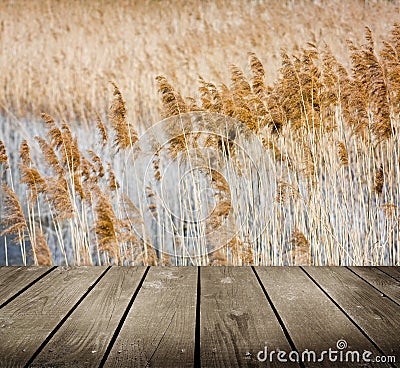 Reed and empty wooden deck table. Stock Photo