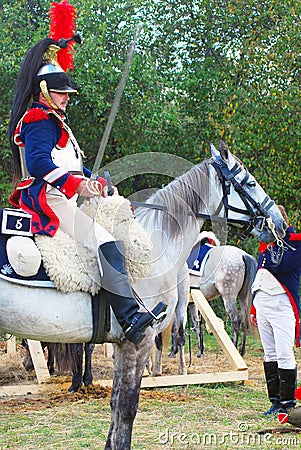 Reenactor-cuirassier dressed as Napoleonic war soldier rides a horse. Editorial Stock Photo
