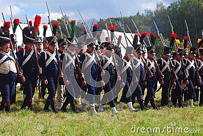 Reenactors dressed as Napoleonic war soldiers march holding guns Editorial Stock Photo