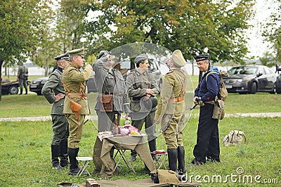 Reenactors dressed in uniforms of German officers of World War II and Russian Tsar army officers of World War I drinking vodka on Editorial Stock Photo