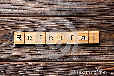 Referral word written on wood block. Referral text on wooden table for your desing, Top view concept Stock Photo