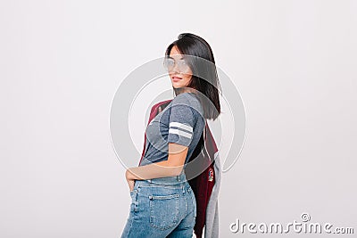 Refined girl with short black hair looking over shoulder, holding bomber in other hand. Pretty lady with trendy haircut Stock Photo