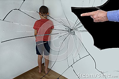 Reflected in the shards of a broken mirror. A punished boy, a junior schoolboy, is standing in the corner, turning to the wall. Stock Photo