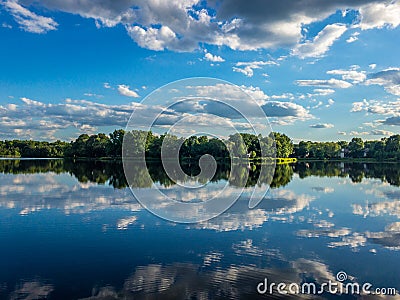 Reflection of the cloudy sky in the water of little lake Stock Photo