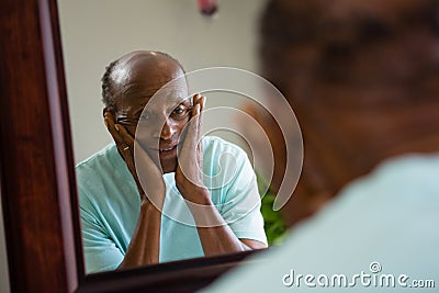 Reflection of concerned senior man on mirror Stock Photo
