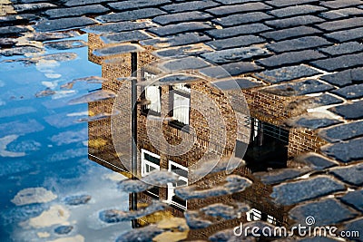 Reflection of House in Puddle Stock Photo