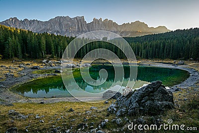 Reflection of Latemar in the clear water of Lake Carezza Karersee in Dolomite Alps, Trentino Alto Adige, South Tirol, Italy Stock Photo