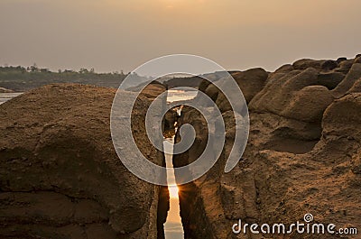 Reflection of morning sun and the river in the broken stone cliff Stock Photo