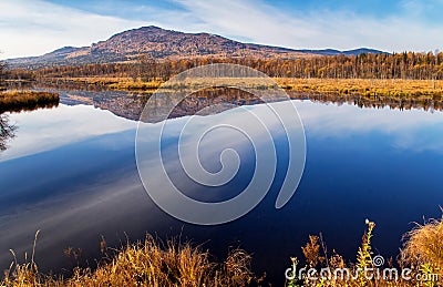 Reflection of mountain and sky in blue water Stock Photo