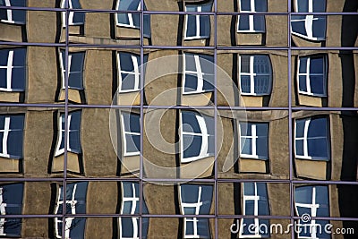 Reflection of old building out of a glasses of a modern corpaorate building (the most distorted windows may seem a bit unsharp at Stock Photo